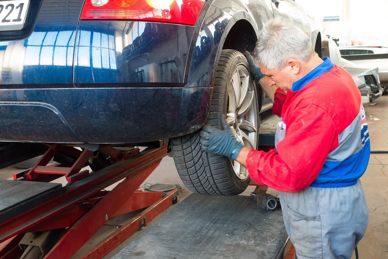 A vehicle raised on a lift inside a repair shop