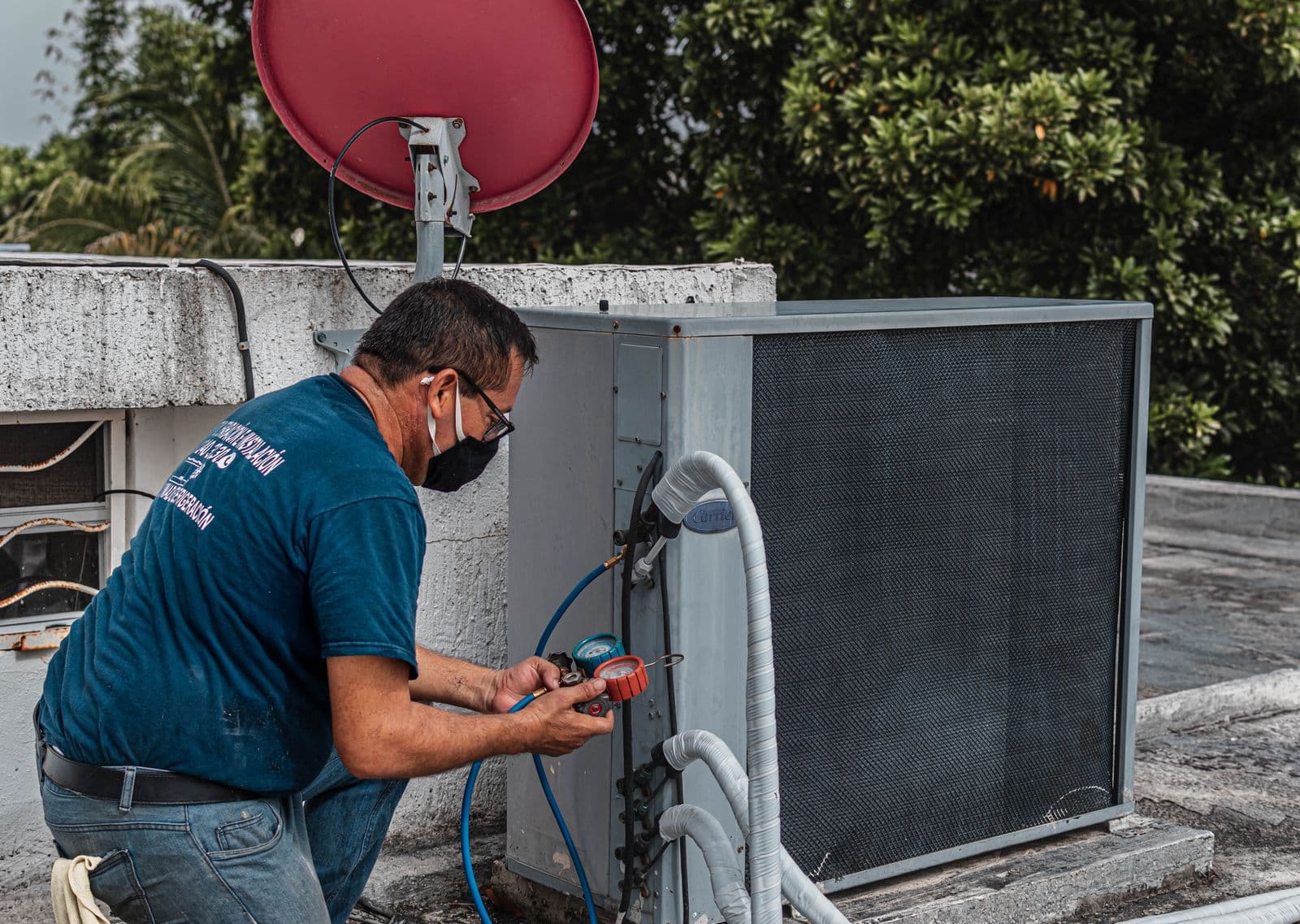 A technician servicing an air conditioning unit