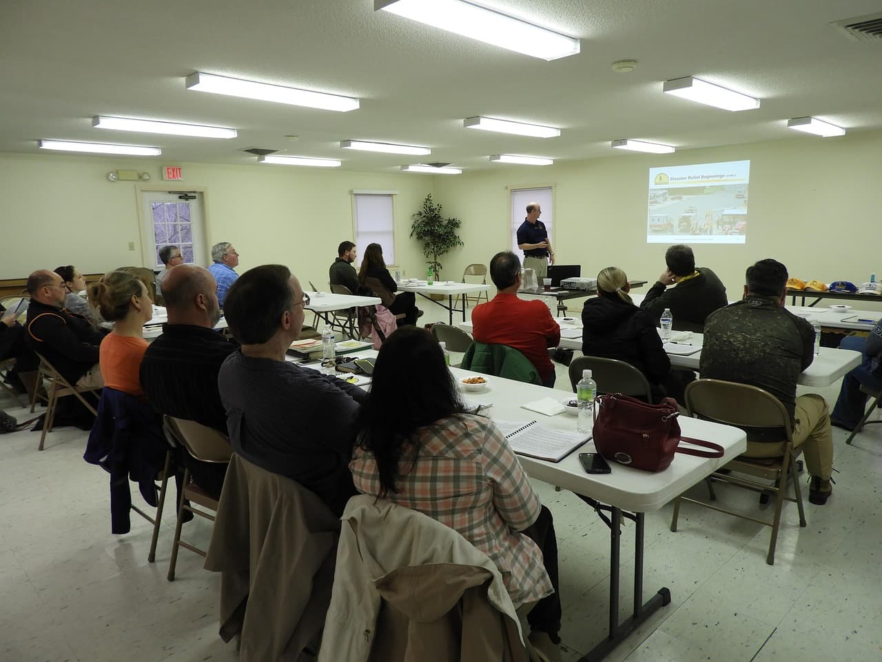 People gathered around tables at a community meeting